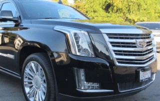 Black luxury SUV parked outdoors, sunny day.